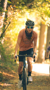 Lifestyle of the Varlo mens parkroad tan explorer cycle crew shirt on a wooded gravel trail.