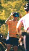 Male model sitting on his bike in the new pioneer gravel cycling jersey in path orange designed by Varlo.